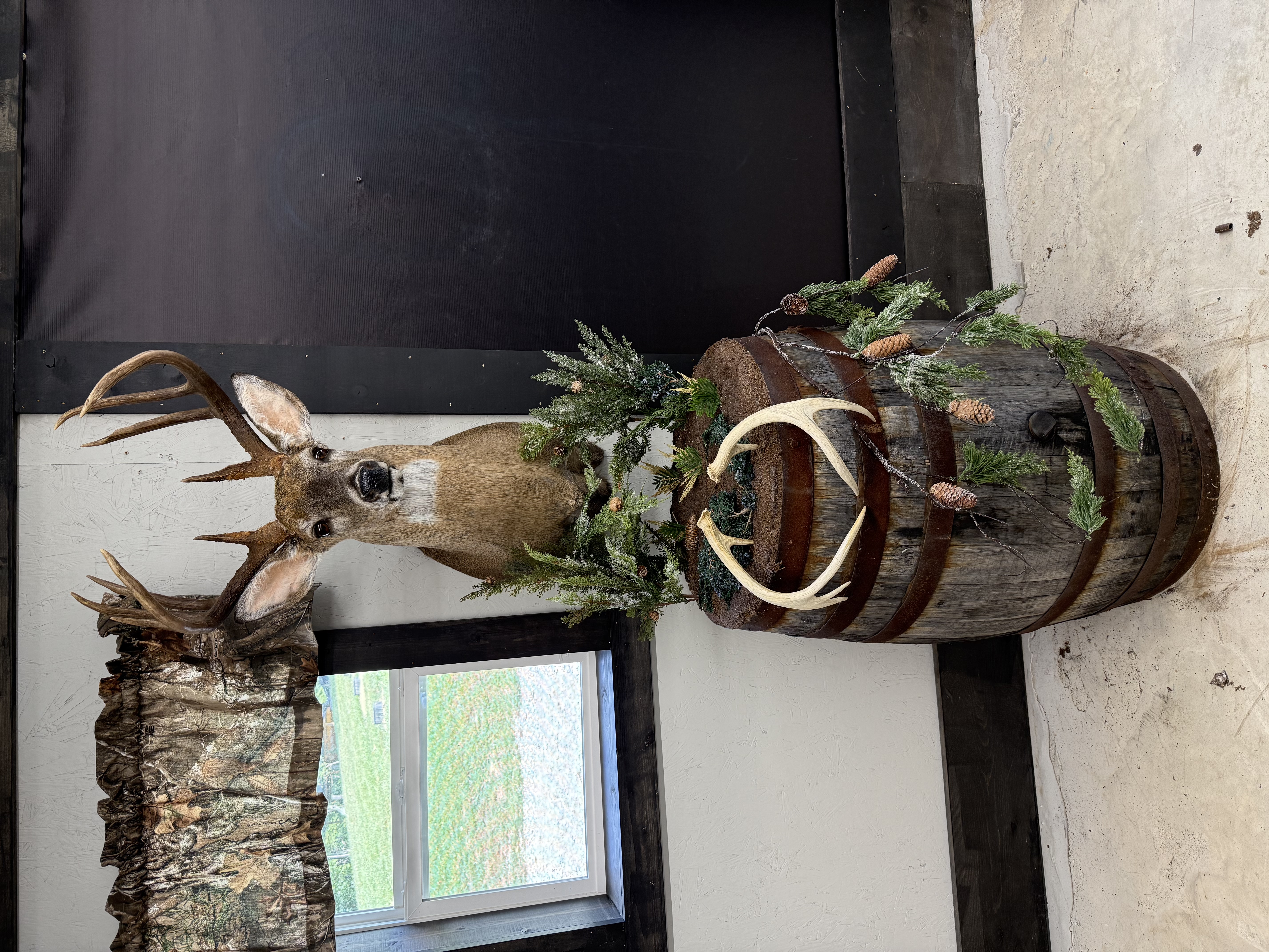 Whitetail deer pedestal mount on custom whiskey barrel base with greenery
