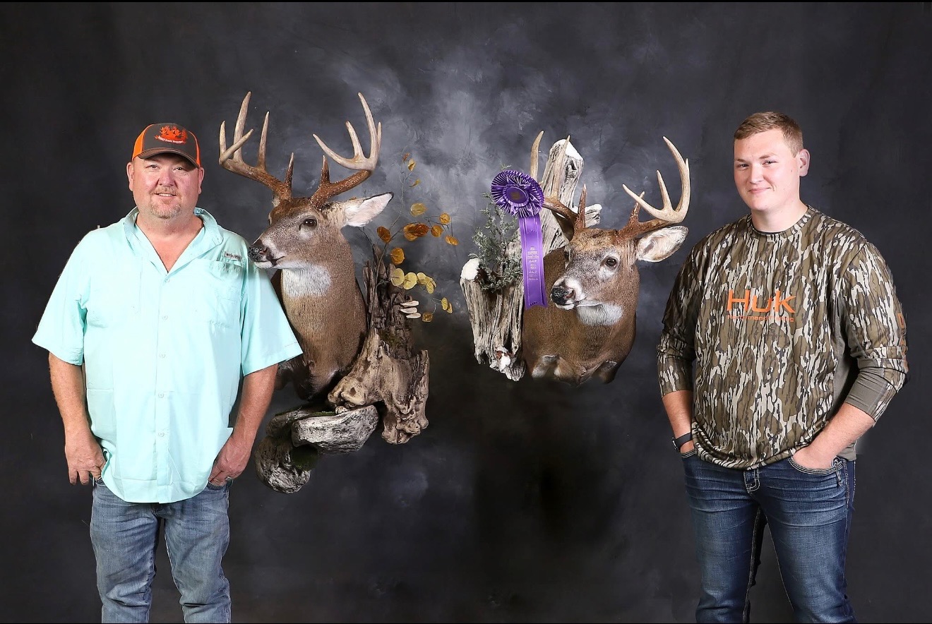 Father and son team with award-winning deer mounts and purple ribbon